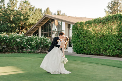 couple kissing in dramatic fashion dipped in front of clubhouse